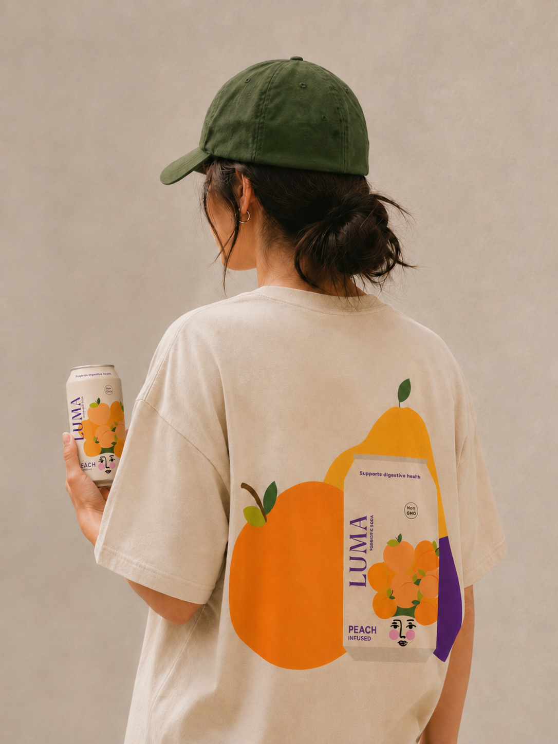 LUMA staff uniform featuring cream t-shirt with fruit illustration and sage green cap